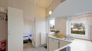 Eine kleine Küche mit Fenster, Spüle und Herd.