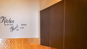 Een keuken met een roestvrijstalen spoelbak, een vaatwasser en een wand met een decoratief tegelpatroon.