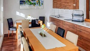 Un coin repas avec une table en bois, des chaises et un vase rempli de fleurs.