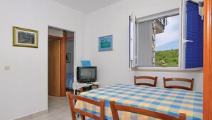 Una habitación con cama, una mesa y sillas. Hay una ventana con vista a zonas verdes.