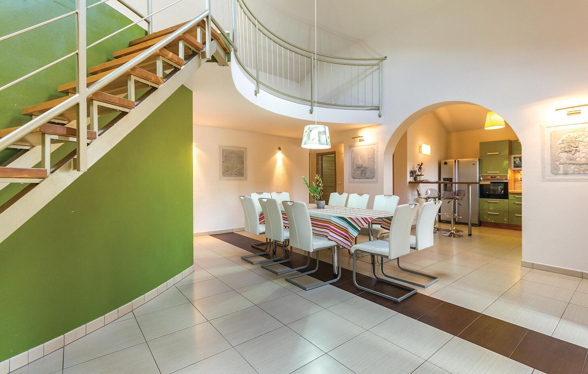 A modern interior with a dining area, kitchen, and staircase.