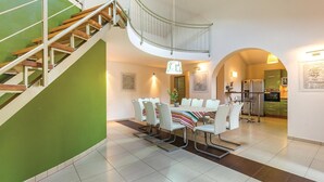 A modern interior with a dining area, kitchen, and staircase. - Amazing home in Medulin (Medulin)