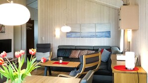 A modern living room with a sofa, a coffee table, and a TV. - Beach front home in Schönhagen (Schönhagen)