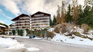 A multi-story hotel with balconies, located in a snowy mountainous area.