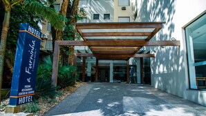 A hotel entrance with a signboard, a covered walkway, and a building facade. - A Furninha Hotel (Torres)