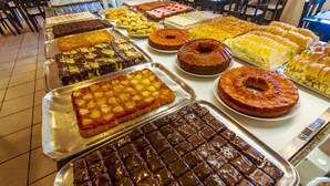 A buffet table with various desserts including cakes, pies, and pastries. - A Furninha Hotel (Torres)