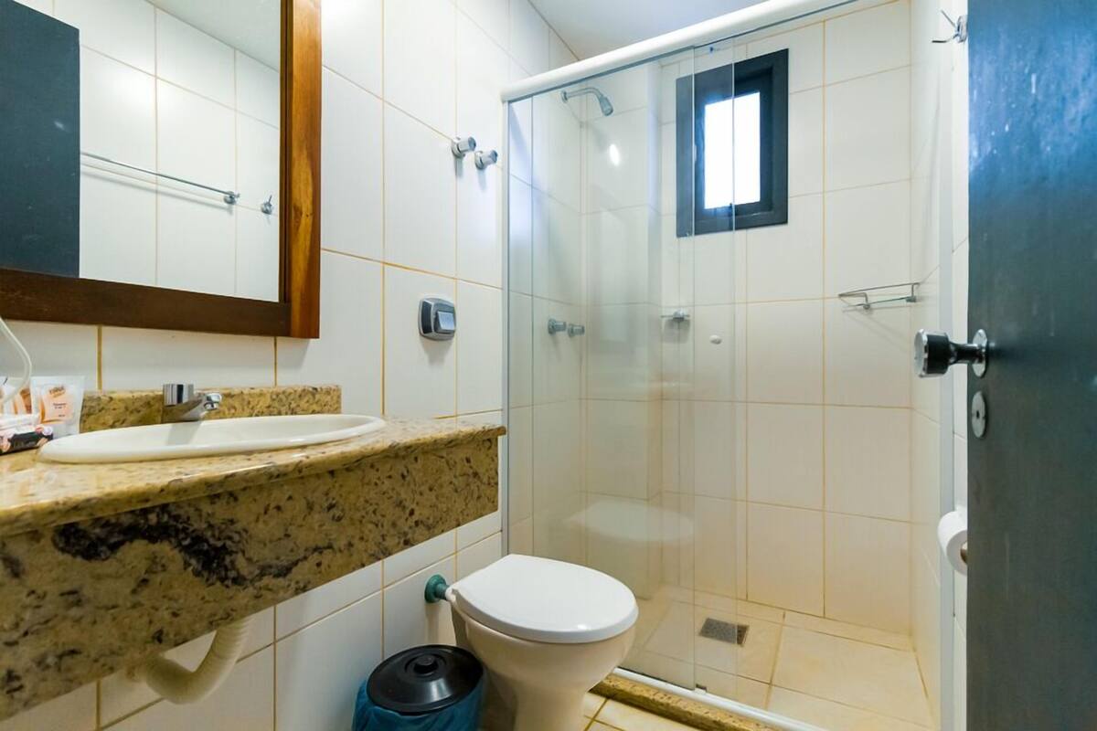 A bathroom with a sink, toilet, and glass shower enclosure.