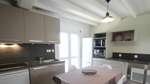Una cocina moderna con zona de comedor, que incluye lavavajillas, estufa, microondas y horno.