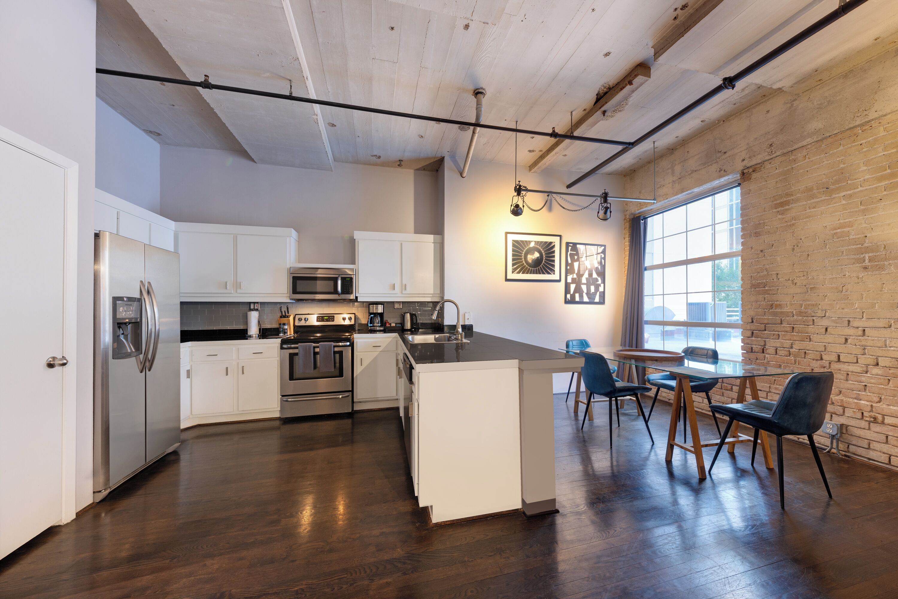 A modern kitchen with white cabinetry, stainless steel appliances, and a central island.