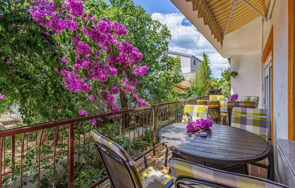 An outdoor patio with a round table and chairs, surrounded by a metal railing. - Cozy apartment in Medulin with WiFi (Medulin)