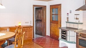 Una cucina con mobili in legno, un tavolo da pranzo con sedie e un forno integrato.
