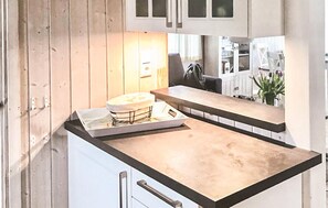 A kitchen with wooden cabinets, a countertop, and a window with natural light. - Pet friendly home in Schönhagen (Schönhagen)