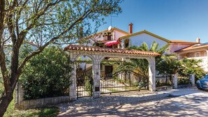 Ein traditionelles Haus im mediterranen Stil mit einem Portal aus Stein, einem Ziegeldach und einem sichtbaren Balkon.