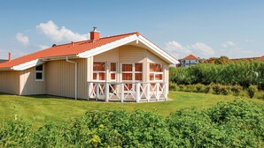 A single-story house with a red-tiled roof and a white porch.