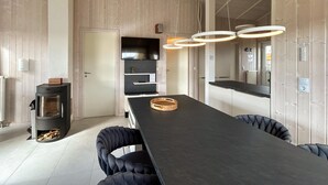 A modern kitchen with a central island, a built-in stove, and pendant lighting.