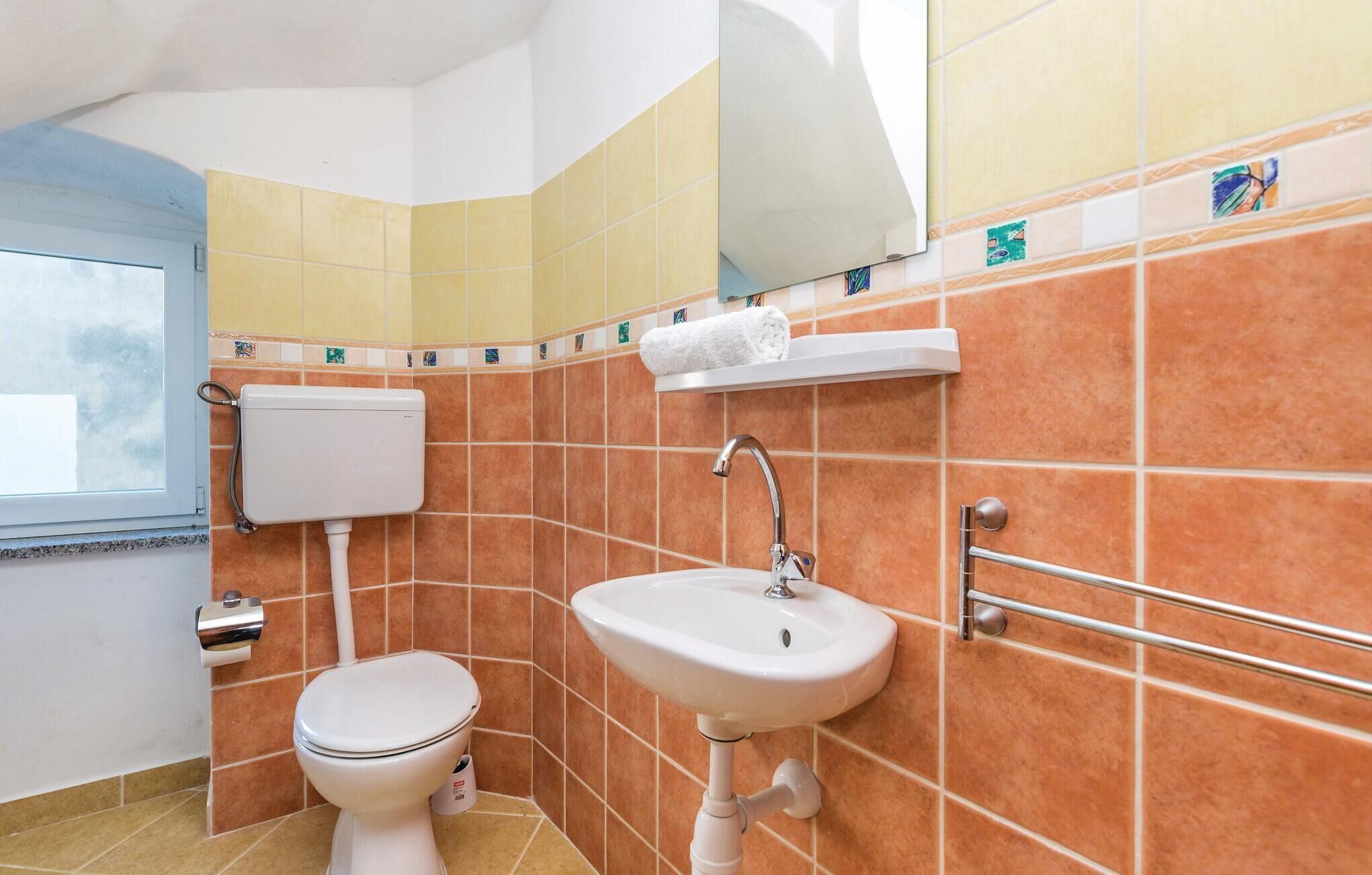 Ein Badezimmer mit Toilette, Waschbecken und Handtuchhalter.