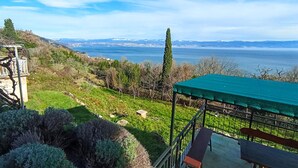 Una terraza con vistas a un lago y montañas lejanas.