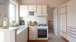 A compact kitchen with white cabinets, a microwave, a stove, and a dishwasher. - Awesome home in Schönhagen with sauna (Schönhagen)