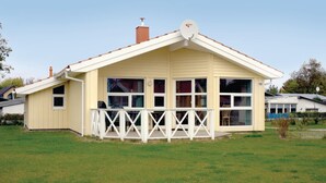 A single-story house with a gabled roof, a balcony with a white railing, and a chimney. - Awesome home in Schönhagen with sauna (Schönhagen)