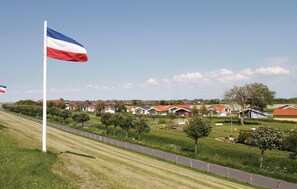 A residential area with houses, a flag, and a well-maintained lawn. - Friedrichskoog-Strandpark 20 (Friedrichskoog)