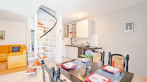 Een modern appartement met een eethoek, keuken en woonkamer.