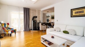 A modern living room with a white sofa, a coffee table, and a colorful armchair. - Luxurious home in Dicmo (Dicmo)