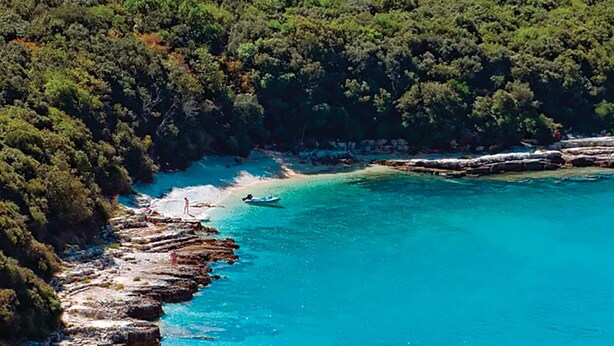 A coastal area with clear turquoise waters, rocky shorelines, and dense green forest. - 2 bedroom gorgeous apartment in Medulin (Medulin)