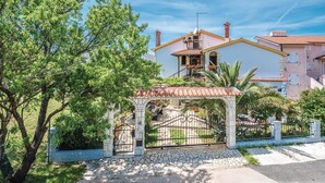A residential building with a tiled roof, a balcony, and a stone gate. - 2 bedroom gorgeous apartment in Medulin (Medulin)