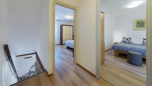 Una camera d'hotel con un letto, un comodino, una lampada e un quadro appeso al muro.