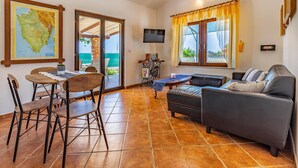 A living room with a sofa, chairs, a TV, a map, and a table. - Lovely home in Medulin (Medulin)