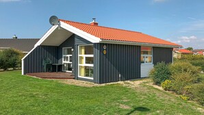 A single-story house with a red-tiled roof, a satellite dish, and a number 15 sign on the front. - Friedrichskoog-Strandpark 15 (Friedrichskoog)