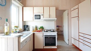 A compact kitchen with white cabinets, a microwave, an oven, and a sink. - Gorgeous home in Schönhagen with sauna (Schönhagen)