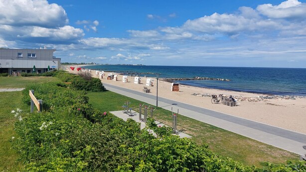 A coastal road with beachside cottages, a paved walkway, and a view of the sea. - Gorgeous home in Schönhagen with sauna (Schönhagen)