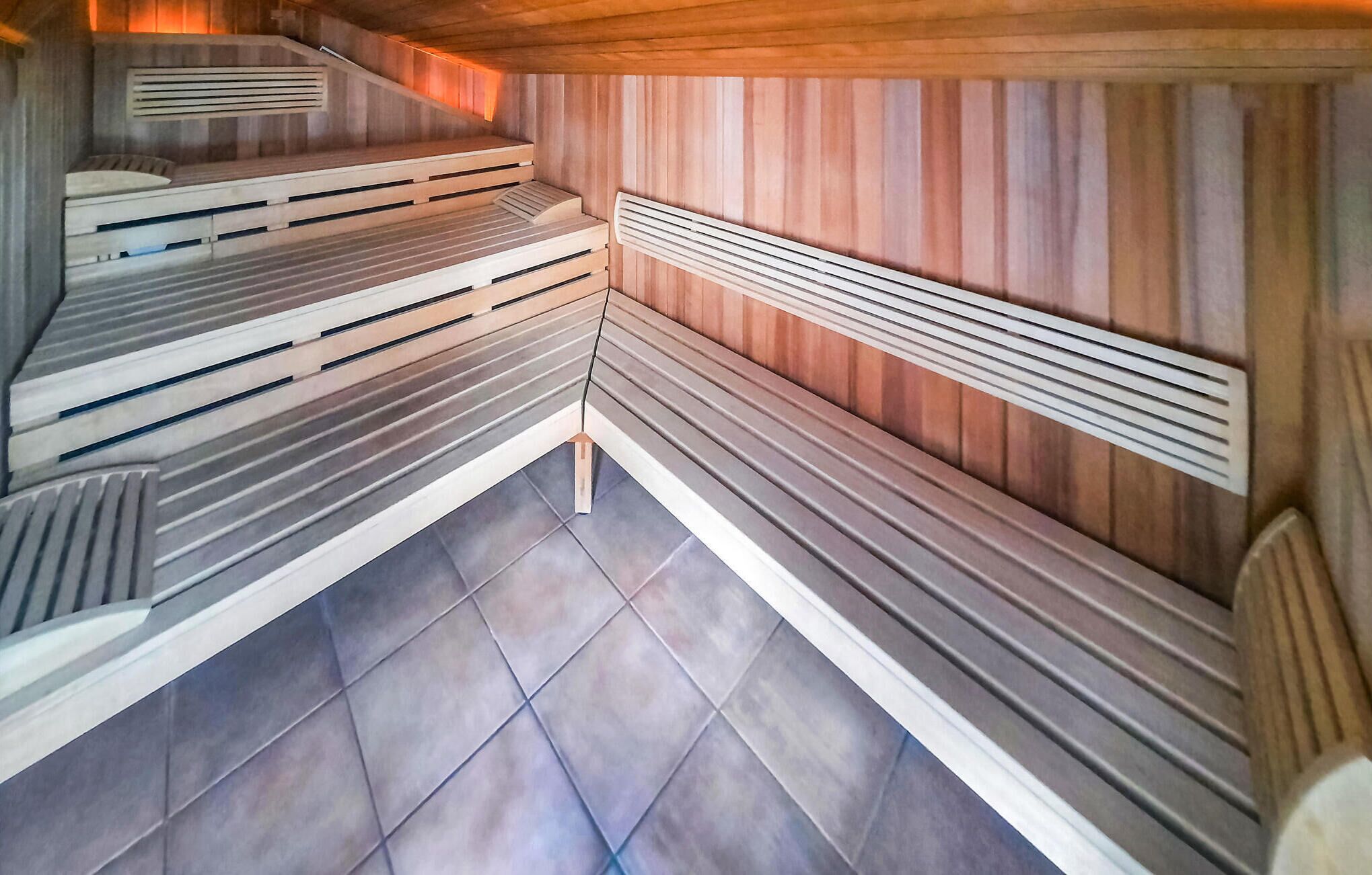 A sauna with tiered benches and a sloped ceiling.