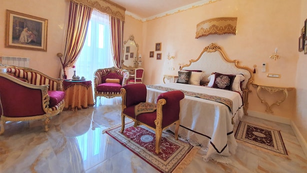 A luxurious bedroom with a large bed, ornate furniture, and a chandelier. - FD Luxury Rooms (Verona)