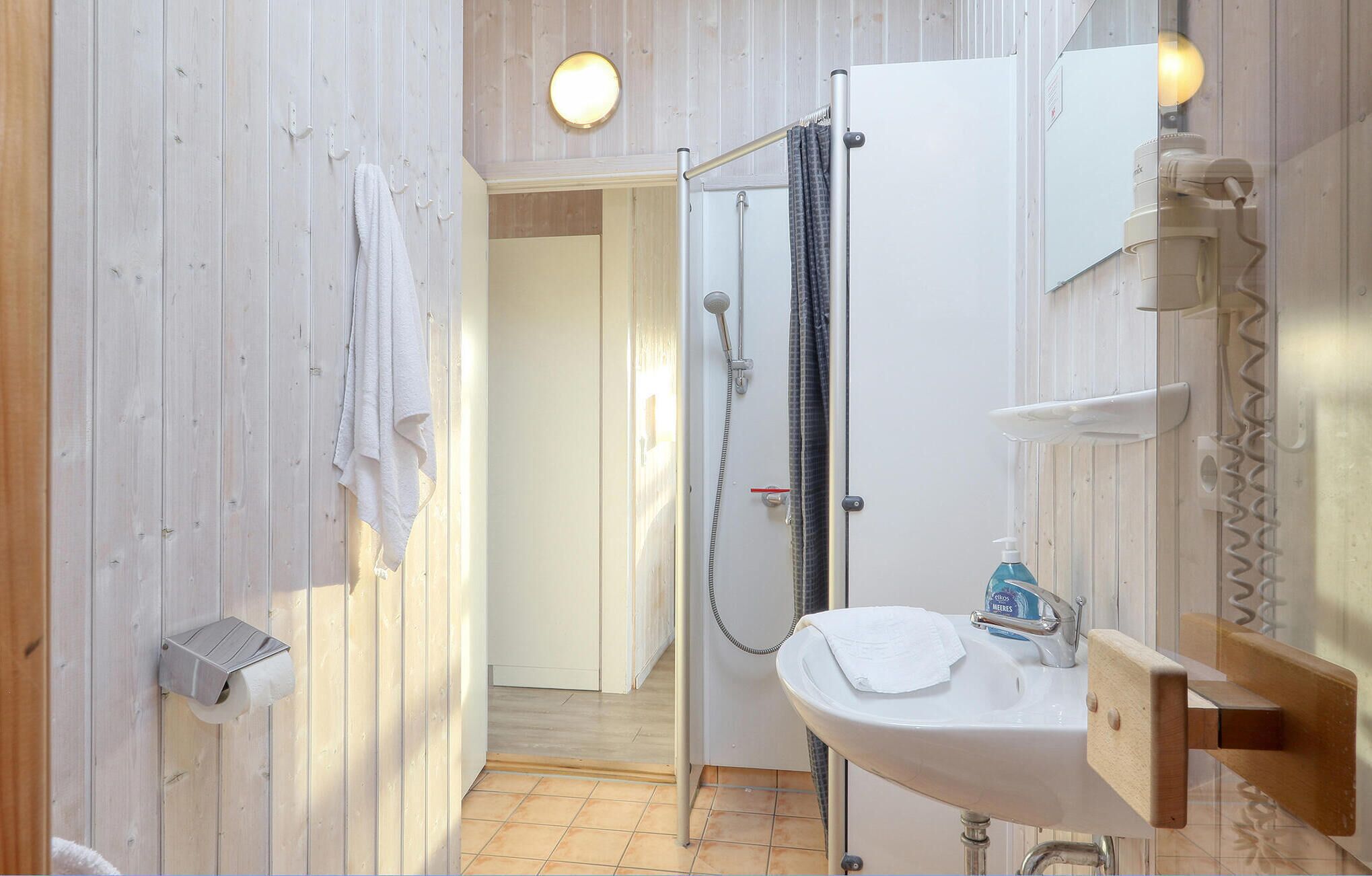A bathroom with a shower, a sink, and a mirror.