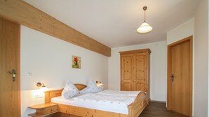 A bedroom with a wooden bed, bedside tables, a wardrobe, and a ceiling light. - Vacation apartment Sunnseitn for 4 persons, 2 bedrooms, 2 balconies, 54 sqm (Inzell)