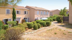 A row of terracotta-roofed houses with a gravel path and greenery in the foreground. - 1 bedroom awesome home in Calvisson (Calvisson)