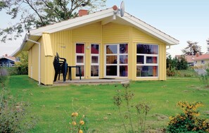 Situated in a residential area, this single-story house features a cozy front porch with a table and chairs.
