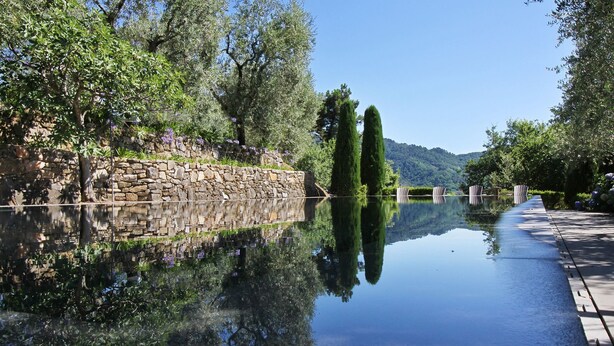 A serene water body reflecting trees and a stone wall, with a clear view of a mountain in the background. - Stunning private villa with WIFI, private pool, TV, patio and panoramic view, close to Lucca (Santo Stefano)