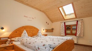 Ein gemütliches Schlafzimmer mit einem hölzernen Bett, einem Oberlicht und einer Wand mit einer Schrift.