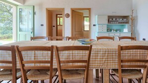 A dining area with a high wooden ceiling, a large table with checkered tablecloths, and wooden chairs with woven seats. - Wonderful private villa with A/C, WIFI, private pool, TV, patio, pets allowed and panoramic view (Umag)