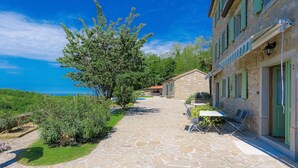A stone-paved courtyard with a view of the sea, surrounded by buildings with green shutters and stone walls. - Wonderful private villa with A/C, WIFI, private pool, TV, patio, pets allowed and panoramic view (Umag)