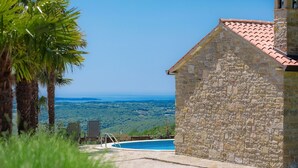 A stone building with a tiled roof overlooking a swimming pool and a scenic view of the countryside. - Wonderful private villa with A/C, WIFI, private pool, TV, patio, pets allowed and panoramic view (Umag)