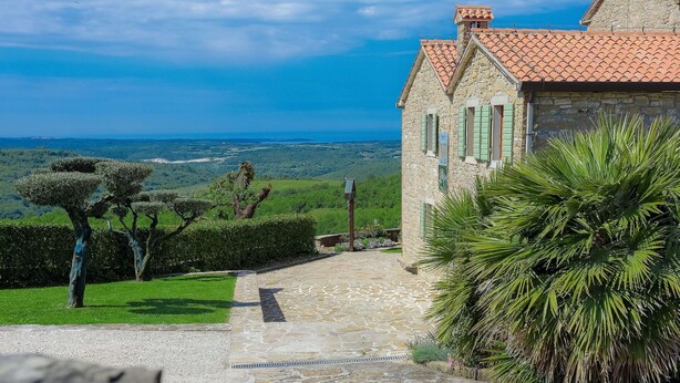 A stone building with a red-tiled roof, a stone pathway leading to it, and a view of the sea in the background. - Wonderful private villa with A/C, WIFI, private pool, TV, patio, pets allowed and panoramic view (Umag)
