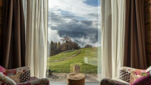 A room with a large window offering a view of a mountainous landscape. - Casera Cornolera (Chies d´Alpago)