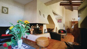 Uma sala de estar acolhedora com lareira, sofá, mesa de centro e televisão.