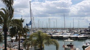 Ein Yachthafen mit zahlreichen Booten, Palmen und blauem Himmel.