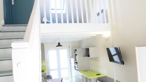 A modern apartment with a kitchen, dining area, and a balcony.