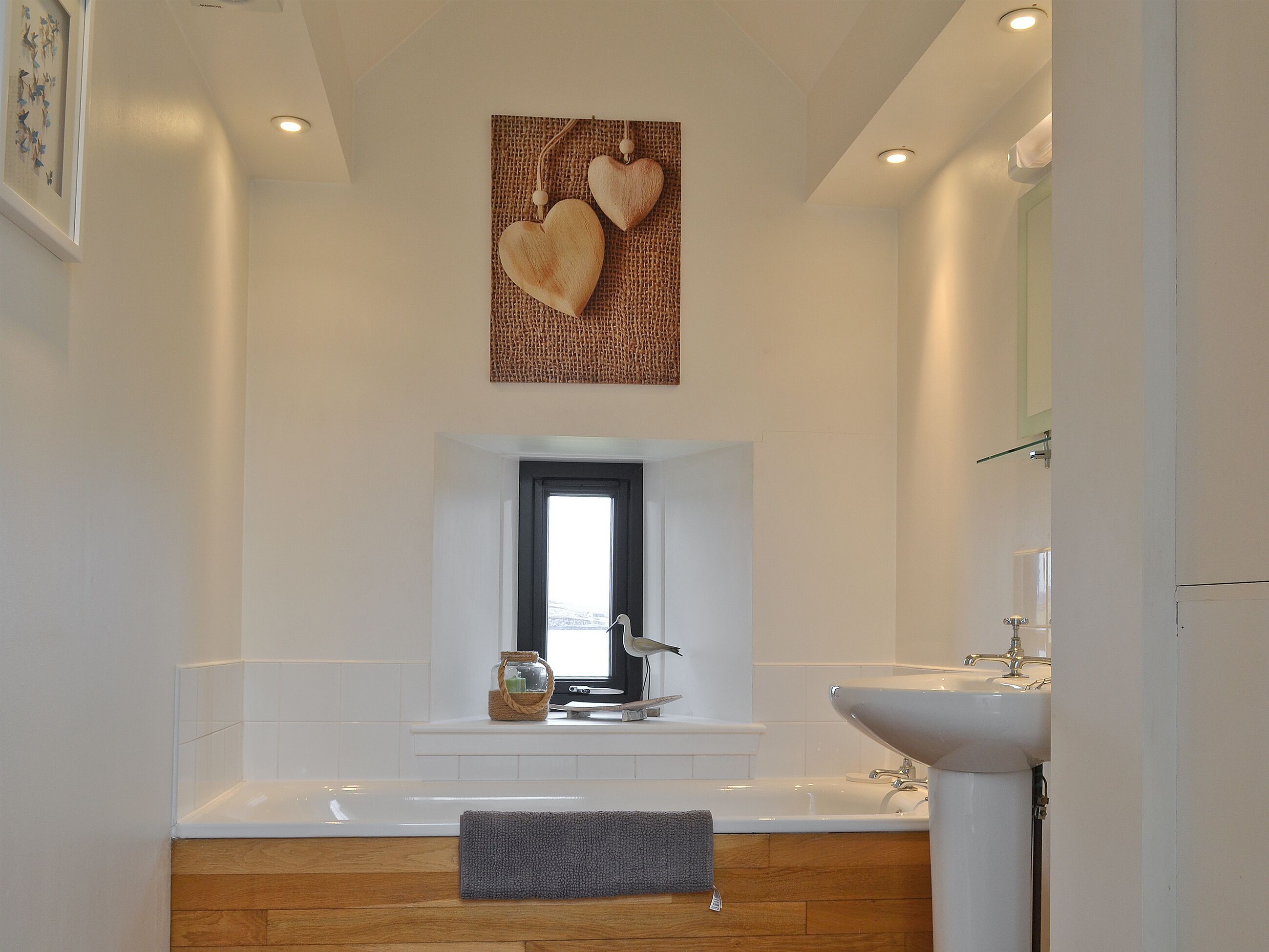 Un baño moderno con bañera, lavamanos y ventana.